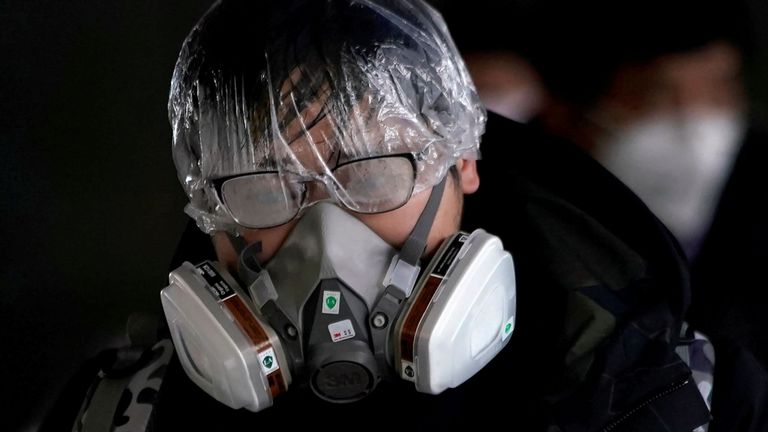 Un passager portant un masque marche à l'extérieur de la gare de Shanghai à Shanghai, Chine