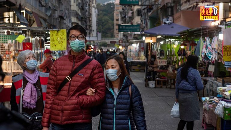 Les gens portent des masques pour prévenir les infections dans un marché de rue à Hong Kong