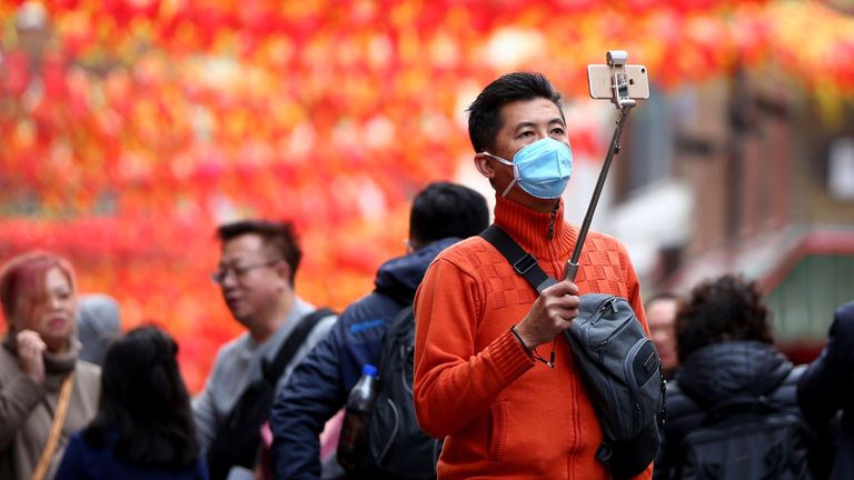 Un homme porte un masque facial dans le quartier chinois, Londres