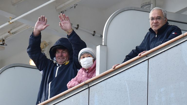 Les passagers à bord du bateau de croisière Diamond Princess regardent depuis leur balcon tandis que le navire accoste au terminal de croisière de la jetée de Daikoku dans le port de Yokohama le 6 février 2020. - Dix autres personnes sur le bateau de croisière au large des côtes du Japon ont été testées positives pour le nouveau coronavirus, a déclaré le ministre de la Santé le 6 février, portant le nombre d'infections détectées sur le bateau à 20. (Photo de Kazuhiro NOGI / AFP) (Photo de KAZUHIRO NOGI / AFP via Getty Images)