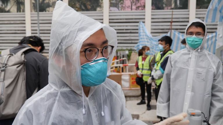 Les vigiles du virus portent un équipement de protection lors de la vérification des nouveaux arrivants à Hong Kong