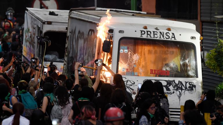 Un véhicule de presse est incendié alors que des femmes défilent à Mexico le 14 février 2020 pour protester contre la violence sexiste. - Plusieurs manifestations ont eu lieu vendredi dans la capitale mexicaine et dans d'autres villes du pays après le meurtre d'Ingrid Escamilla, 25 ans, poignardée à mort puis écorchée par son partenaire dans le nord de Mexico le 9 février.