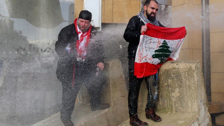 Des manifestants à Beyrouth sont aspergés d'un canon à eau tout en essayant d'empêcher les députés d'atteindre le Parlement