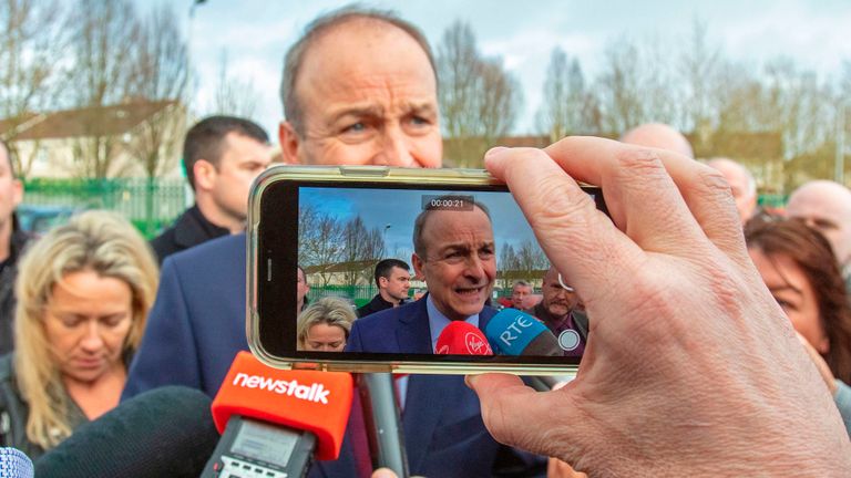Le chef du parti irlandais Fianna Fail, Micheal Martin (C) est filmé alors qu'il s'adresse aux membres des médias à l'extérieur du centre de comptage de Cork