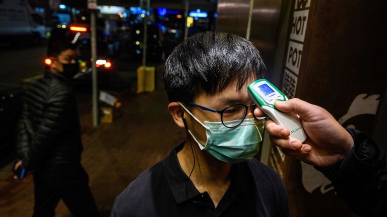 Un employé d'un restaurant fait prendre sa température à Hong Kong
