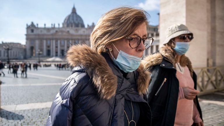 Les touristes portant des masques faciaux visitent la place Saint-Pierre sur la place du Vatican, Rome