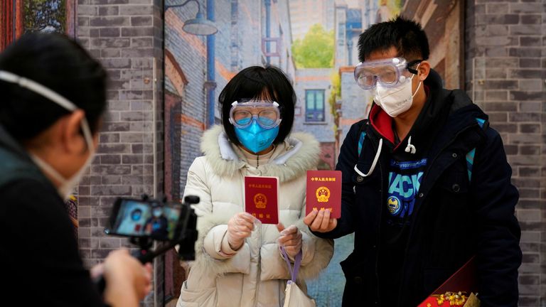 Su, 28 ans (L) et Jia, 29 ans, se sont mariés - portant des masques faciaux - dans un bureau d'enregistrement le jour de la Saint-Valentin à Shanghai