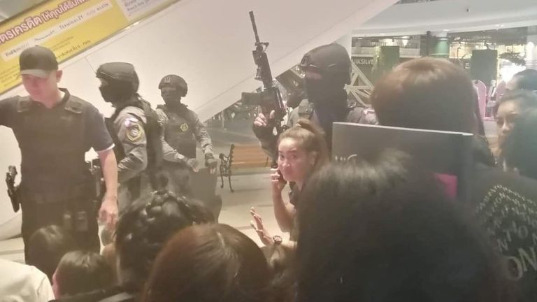 Des personnes sont évacuées du centre commercial Terminal 21 par des membres des forces de sécurité 