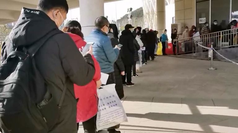 Ceux qui montrent des signes de coronavirus font la queue devant un hôpital de fortune à Wuhan