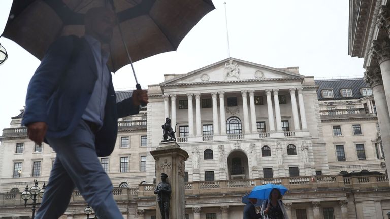 Les piétons s'abritent sous des parapluies devant le Royal Exchange et la Banque d'Angleterre, à Londres