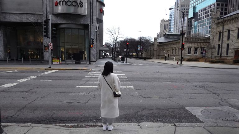 Une femme attend que la lumière change avant de traverser Michigan Avenue le long du quartier commerçant de Magnificent Mile le 20 mars 2020 à Chicago, Illinois
