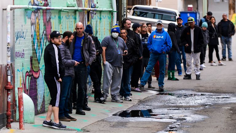 DENVER, CO - 23 mars: les gens se tiennent dans des cercles fraîchement peints, à six pieds de distance, alors qu'ils attendent dans une ligne de deux heures pour acheter des produits de marijuana de Good Chemistry le 23 mars 2020 à Denver, Colorado.