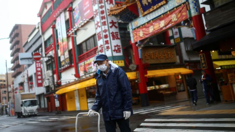 Un travailleur, portant un masque protecteur après une épidémie de coronavirus (COVID-19), est photographié dans une rue presque vide du quartier chinois de Yokohama, au sud de Tokyo, au Japon, le 10 mars 2020. REUTERS / Edgard Garrido