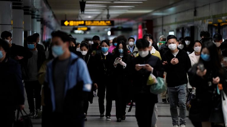 Des passagers portant des masques faciaux sont vus à Shanghai après le déclassement du niveau d'alerte d'urgence pour le coronavirus de la ville