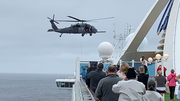 Les passagers du Grand Princess regardent un hélicoptère atterrir alors qu'il livre des kits de test de coronavirus