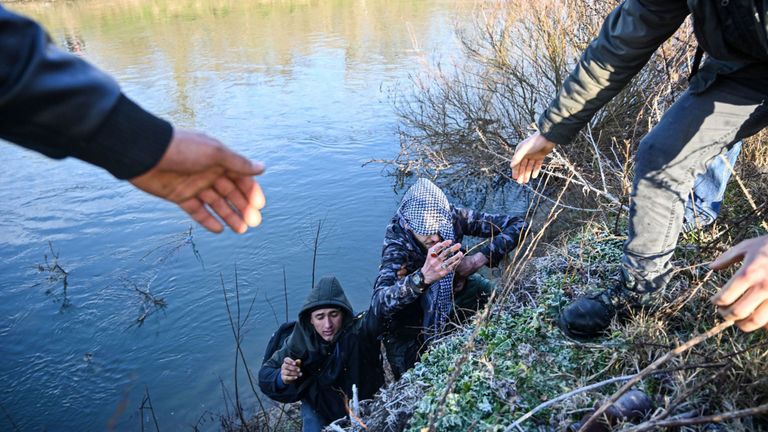 Les migrants s'entraident après une tentative d'entrer en Grèce depuis un endroit près d'Edirne, Turquie