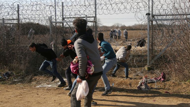 Des migrants jettent des pierres sur un véhicule militaire grec à la frontière turco-grecque au passage frontalier de Pazarkule en Turquie avec les Kastanies de la Grèce