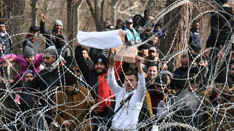 Les migrants qui souhaitent entrer en Grèce depuis le poste frontalier de Pazarkule en Turquie crient des slogans alors qu'ils sont rassemblés à la frontière de Kastanies