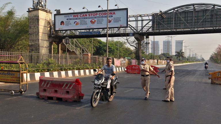 Des policiers tentent d'arrêter un motard à une barrière en Inde