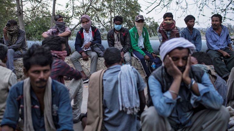 Les travailleurs au salaire quotidien et les sans-abri attendent de la nourriture devant un abri à Delhi