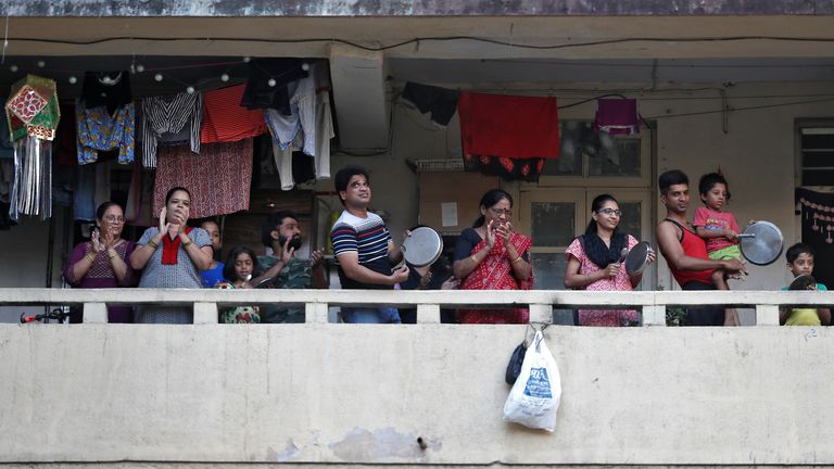 Des résidents applaudissent et frappent des ustensiles de leur balcon pour encourager le personnel d'urgence et les travailleurs de l'assainissement qui sont en première ligne dans la lutte contre le coronavirus, à Mumbai, en Inde, le 22 mars 2020. REUTERS / Francis Mascarenhas