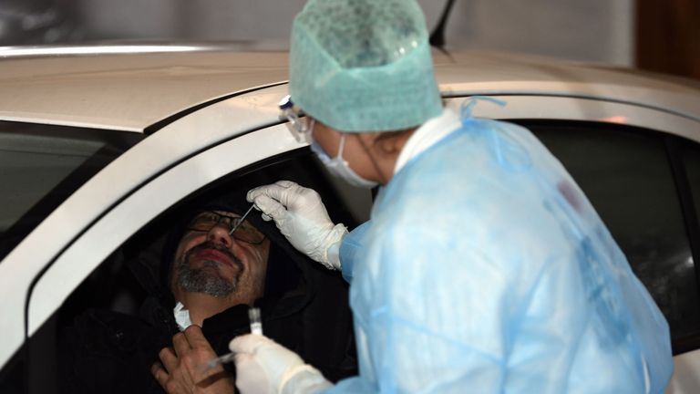 Un travailleur médical prend un écouvillon nasal dans une installation de service au volant à Liège, Belgique
