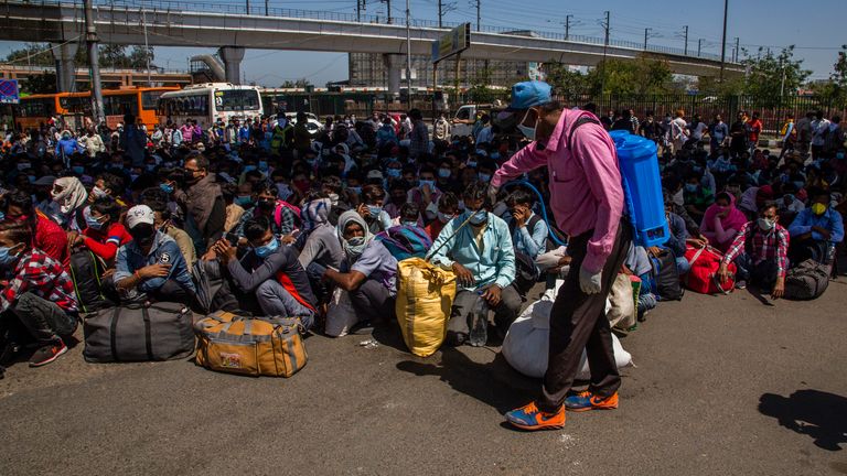 Les travailleurs migrants attendent de monter à bord des bus à New Delhi