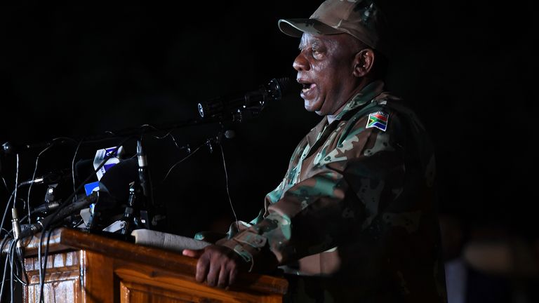 Le président sud-africain Cyril Ramaphosa vêtu de fatigues militaires s'entretient avec des soldats des Forces de défense nationale sud-africaines (SANDF) à la base militaire de Doornkop à Soweto, le 26 mars 2020