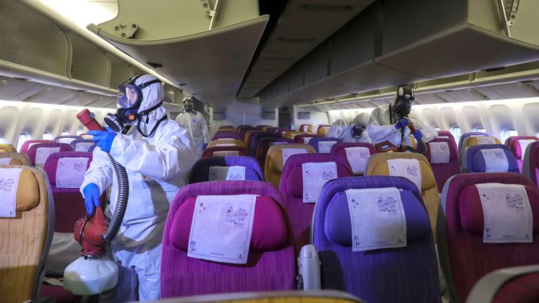 Des membres de l'équipage de Thai Airways désinfectent la cabine d'un avion du transporteur national au cours d'une procédure visant à empêcher la propagation du coronavirus à l'aéroport international Suvarnabhumi de Bangkok