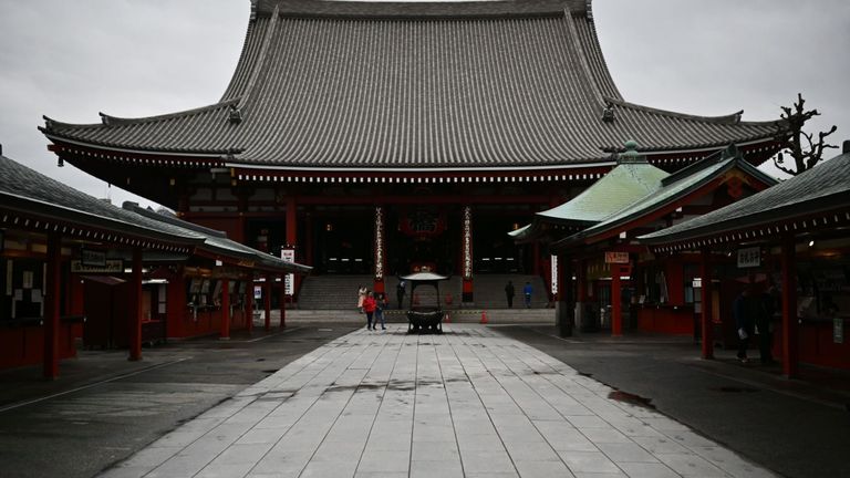 Un petit nombre de touristes visitent le temple Sensoji presque vide dans le quartier Asakusa de Tokyo le 9 mars 2020, alors que le tourisme à travers l'Asie baisse en raison des restrictions en place en raison du coronavirus COVID-19. (Photo de CHARLY TRIBALLEAU / AFP) (Photo de CHARLY TRIBALLEAU / AFP via Getty Images)