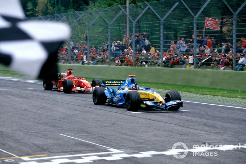 Le vainqueur de la course Fernando Alonso, Renault R25, prend le drapeau à damier, suivi de Michael Schumacher, Ferrari F2005