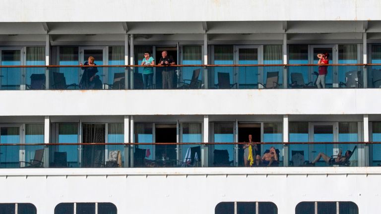 Les passagers sont vus à bord du navire de croisière Holland America Zaandam alors qu'il entrait dans la baie de Panama City pour être assisté par le navire de croisière Rotterdam avec des fournitures, du personnel et des appareils de test COVID-19, à huit milles au large de Panama City, le 27 mars 2020. - Quatre passagers sont morts à bord d'un bateau de croisière transportant des dizaines de personnes présentant des symptômes pseudo-grippaux, bloqués au large des côtes du Pacifique en Amérique du Sud depuis plusieurs jours, a annoncé vendredi la compagnie de ligne. Le Zaandam, avec 1 800 passagers à bord, se trouve actuellement dans les eaux territoriales du Panama, après avoir été empêché de s'amarrer dans plusieurs pays en raison de craintes de coronavirus. (Photo Ivan PISARENKO / AFP) / La mention erronée[s] apparaissant dans les métadonnées de cette photo d'Ivan Pisarenko a été modifié dans les systèmes AFP de la manière suivante: [Ivan Pisarenko] au lieu de [Luis Acosta]. Veuillez supprimer immédiatement la mention erronée[s] de tous vos services en ligne et supprimez-les de vos serveurs. Si vous avez été autorisé par l'AFP à les (les) distribuer à des tiers, veuillez vous assurer que les mêmes actions sont effectuées par eux. Le non-respect rapide de ces instructions entraînera une responsabilité de votre part pour toute utilisation continue ou post-notification. Par conséquent, nous vous remercions beaucoup pour toute votre attention et votre action rapide. Nous sommes désolés des inconvénients que cette notification peut causer et restons à votre disposition pour toute information complémentaire dont vous pourriez avoir besoin. (Photo par IVAN PISARENKO / AFP via Getty Images)