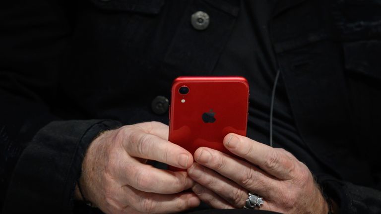 Le chanteur du groupe de rock irlandais U2 Bono tient son iphone 