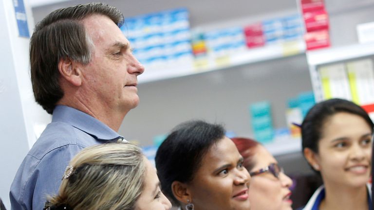 Le président brésilien Jair Bolsonaro pose pour des photos avec des employés d'une pharmacie, au milieu de l'épidémie de maladie à coronavirus (COVID-19), à Brasilia, Brésil, le 10 avril 2020. REUTERS / Adriano Machado