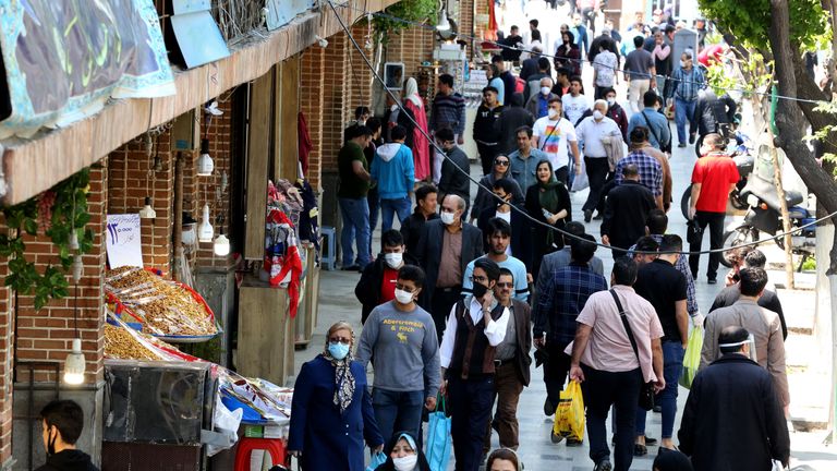 Des Iraniens, certains portant des équipements de protection au milieu de la pandémie de COVID-19, font leurs achats dans une rue près du marché du Grand Bazar à Téhéran, le 18 avril 2020. - L'Iran a permis à certaines entreprises fermées de Téhéran de rouvrir le 18 avril, malgré le épidémie de coronavirus la plus meurtrière, car beaucoup étaient confrontés à un choix amer entre le risque d'infection et la ruine économique. (Photo par ATTA KENARE / AFP) (Photo par ATTA KENARE / AFP via Getty Images)