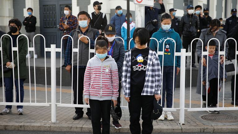 Des personnes portant des masques faciaux se tiennent dans la rue pour rendre hommage alors que la Chine organise un deuil national pour ceux qui sont morts de la maladie des coronavirus (COVID-19)