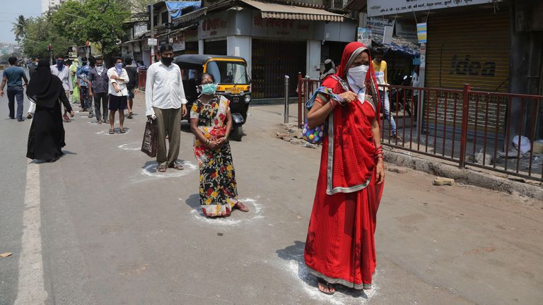 Les gens se trouvent dans des positions marquées pour acheter des produits essentiels dans une épicerie de Mumbai, en Inde, le mercredi 25 mars 2020. La plus grande démocratie du monde est passée sous le plus grand blocage du monde mercredi, avec l'Inde & # 39; s 1,3 milliard de personnes ont reçu l'ordre de rester à la maison afin d'empêcher la pandémie de coronavirus de se propager et de submerger son fragile système de santé comme elle l'a fait ailleurs. Pour la plupart des gens, le nouveau coronavirus provoque des symptômes légers ou modérés, tels que de la fièvre et de la toux qui disparaissent