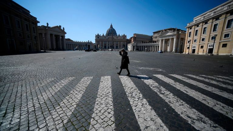 Une femme marche sur une place déserte du Pape Pie XII à Rome