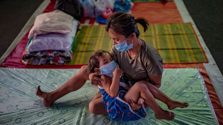 MANILLE, PHILIPPINES - 1 avril: un enfant sans-abri et sa mère portant des masques se reposent à l'intérieur d'un gymnase transformé en refuge pour les sans-abri qui ne peuvent pas se nourrir et ne peuvent pas travailler en raison des mesures de verrouillage du gouvernement le 1er avril 2020 à Manille, Philippines . Le gouvernement philippin a bouclé Luzon, l'île la plus grande et la plus peuplée du pays, pour empêcher la propagation de COVID-19. Les voyages par voie terrestre, maritime et aérienne ont été suspendus, tandis que les travaux du gouvernement, les écoles et les entreprises