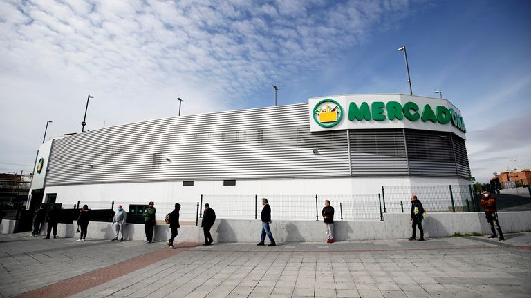 La distance sociale des gens en attendant d'entrer dans un supermarché à Madrid
