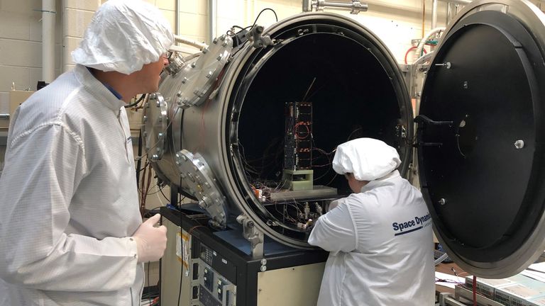 L'ingénieur des systèmes HARP Ryan Martineau (à gauche) et la spécialiste du vide thermique Brittany Woytko configurent le vaisseau spatial HARP dans une chambre à vide thermique au Space Dynamics Laboratory de Logan, dans l'Utah. Woytko connecte plusieurs capteurs de température au vaisseau spatial pour surveiller l'instrument pendant les tests. Une fois la porte fermée sur la chambre, elle perd son air et simule le vide de l'espace. La chambre chauffe et refroidit également le vaisseau spatial à travers plusieurs cycles pour simuler l'extrême chaud et col