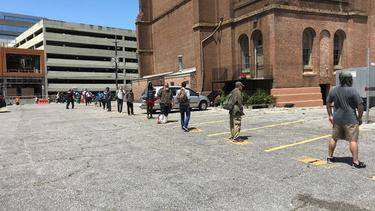 Les gens sont mis à distance sociale dans la file d'attente pour un centre pour sans-abri
