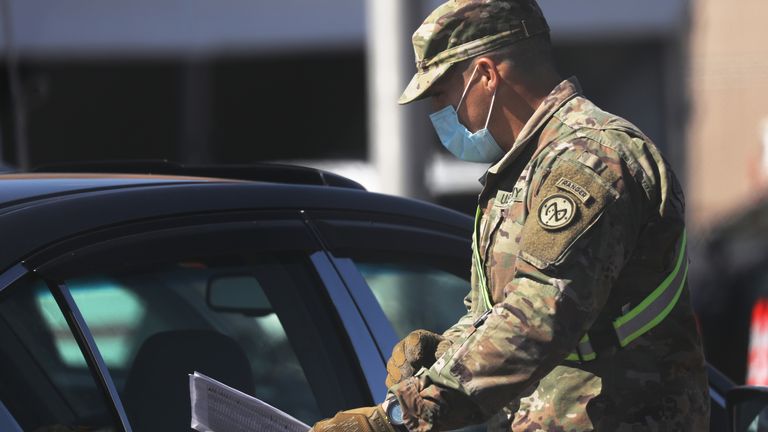Des membres de la Garde nationale communiquent avec des individus sur un site de test de coronavirus récemment ouvert à Brooklyn le 11 avril 2020 dans le quartier de Brooklyn à New York. Selon l'Université John Hopkins, le nombre de morts dans le monde à partir de COVID-19 a maintenant atteint 100 000 dans le monde, de nombreux experts estimant que ce nombre est en fait plus élevé.