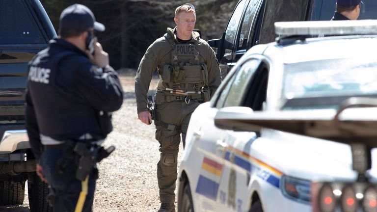Des agents de la GRC se tiennent sur le chemin de la plage de Portapique après que Gabriel Wortman, un tireur présumé, a été arrêté et décédé plus tard, selon les médias locaux, à Portapique, Nouvelle-Écosse, Canada, le 19 avril 2020