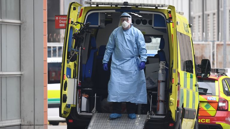 Un agent de santé porte un EPI alors qu'il se tient dans une ambulance après avoir transféré un patient au Royal London Hospital dans l'est de Londres le 18 avril 2020, lors de la nouvelle pandémie de coronavirus COVID-19
