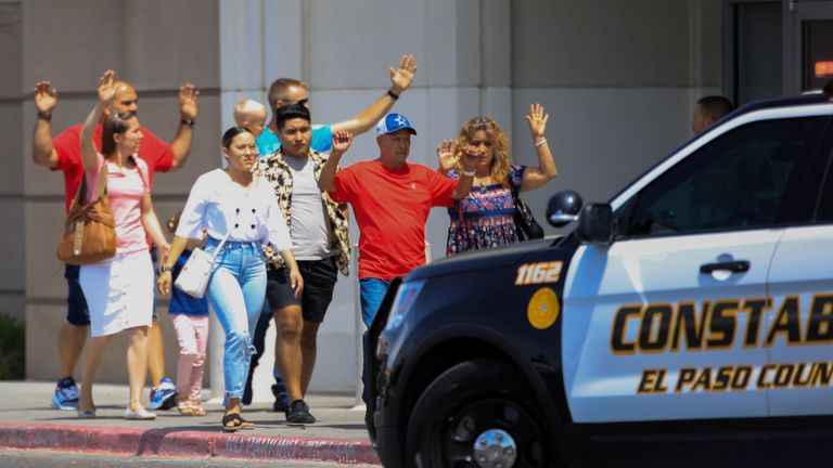 Les acheteurs sortent avec les mains levées après une fusillade de masse dans un Walmart à El Paso