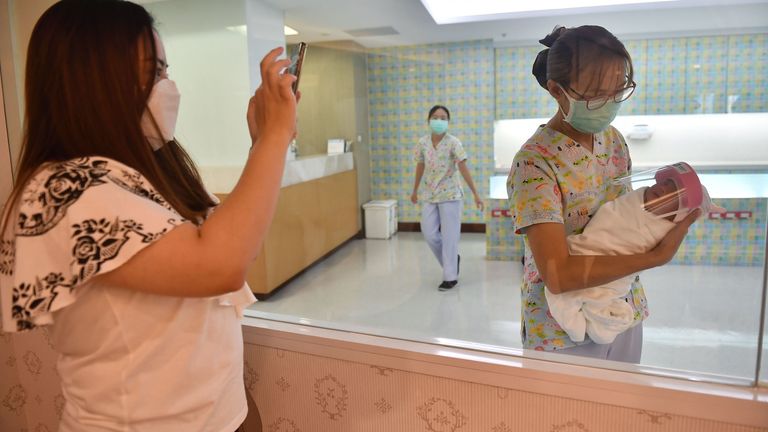 Un nouveau-né portant un écran facial, dans le but de stopper la propagation du COVID-19 à l'hôpital Praram 9 à Bangkok