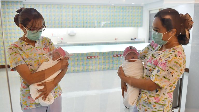 Un nouveau-né portant un écran facial, dans le but de stopper la propagation du COVID-19 à l'hôpital Praram 9 à Bangkok