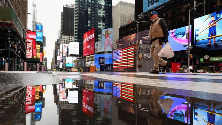 Un homme traverse la rue à un Time Square presque vide le 09 avril 2020 à New York. 