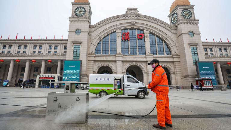 Un travailleur désinfecte la place en face de la gare de Hankou, fermée après la fermeture de la ville de Wuhan